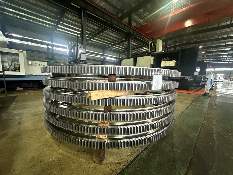 Stack of large-diameter slewing rings with external teeth ready for assembly